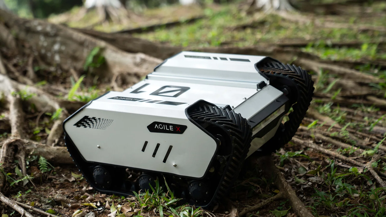 BUNKER MINI 2.0 na leśnej ściółce między korzeniami drzew - kompaktowa platforma gąsienicowa (zdjęcie producenta)